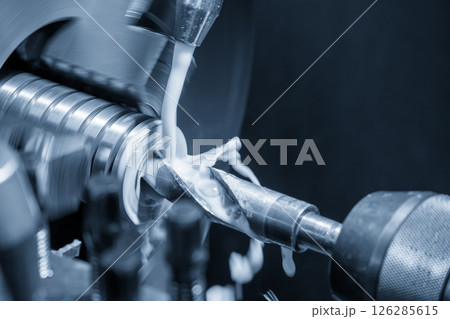 Close up scene lathe machine hole drilling process with liquid coolant method in the light blue scene. Close up scene lathe machine hole drilling process with liquid coolant method in the light blue scene. 126285615