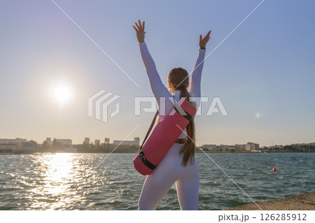 Yoga Sunset Beach Woman - Woman practices yoga on the beach at sunset. Yoga Sunset Beach Woman - Woman practices yoga on the beach at sunset. 126285912