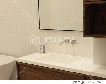 A Modern Bathroom Vanity featuring a Stylish Sink along with an Elegant Mirror included 126287078