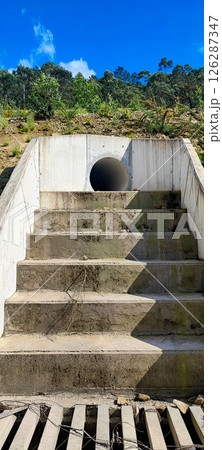 Large concrete pipe for drainage in the rocky regions of Portugal. Concept for drainage works, water treatment, slope stabilization in building construction Large concrete pipe for drainage in the rocky regions of Portugal. Concept for drainage works, water treatment, slope stabilization in building construction 126287347