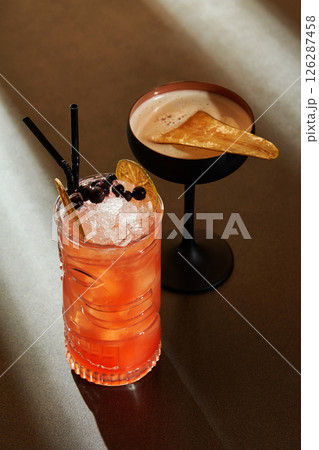 Two refreshing cocktails with fruit and ice sitting on bar Two refreshing cocktails with fruit and ice sitting on bar 126287458