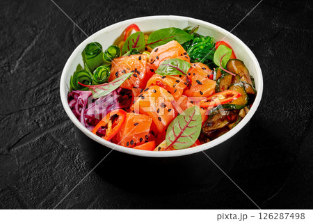 Fresh and delicious poke bowl with salmon, rice and vegetables seasoned with sesame and chili pepper Fresh and delicious poke bowl with salmon, rice and vegetables seasoned with sesame and chili pepper 126287498