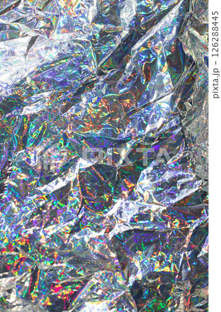 Close-up of holographic foil reflecting iridescent light patterns and vibrant colors 126288445