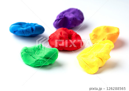 Colorful modeling clay pieces arranged on a white background, vibrant textures visible 126288565