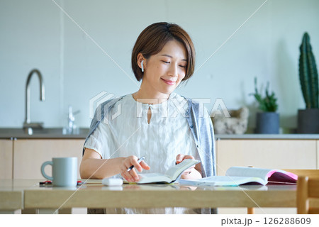 イヤホンをつけて勉強をする女性 イヤホンをつけて勉強をする女性 126288609