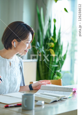 イヤホンをつけて勉強をする女性 126288612