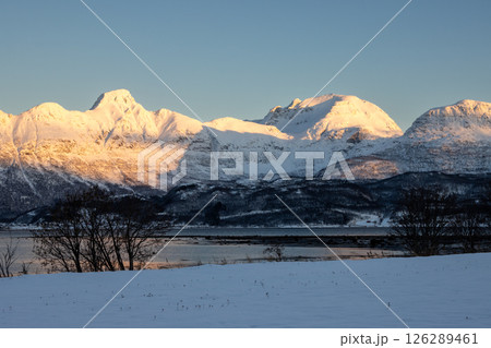 Mountains with snow in sunrise, Hamnvik, Norway Mountains with snow in sunrise, Hamnvik, Norway 126289461