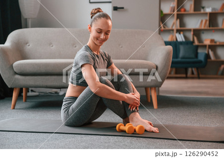 In apartment. Young woman in yoga clothes doing fitness indoors 126290452