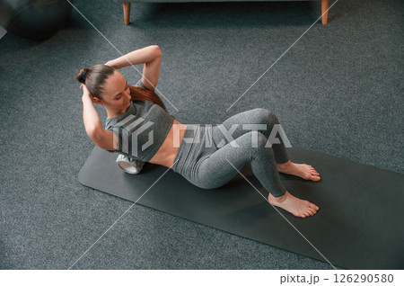 Young woman in yoga clothes doing fitness indoors 126290580