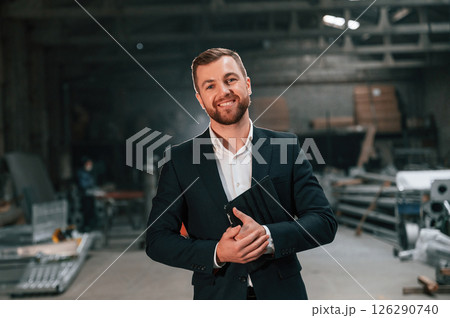 Friendly manager in black formal wear at the factory Friendly manager in black formal wear at the factory 126290740