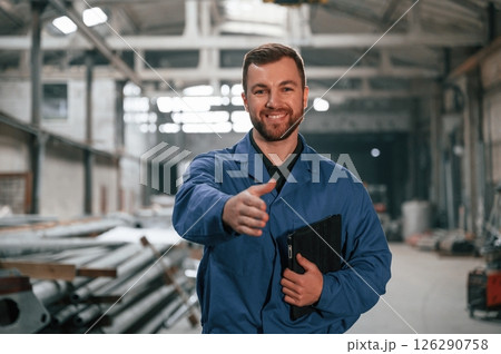 Factory worker in blue uniform is indoors Factory worker in blue uniform is indoors 126290758