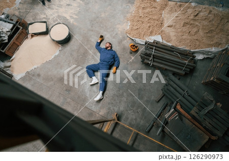 Top view of dead factory worker that lying on the ground. Conception of safety, bad accident 126290973
