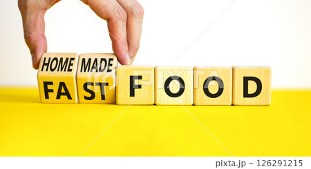 Fast or homemade food symbol. Concept words Fastfood or Homemade food on wooden cubes. Beautiful yellow table white background. Doctor hand. Healthy lifestyle Fast or homemade food concept. Copy space 126291215