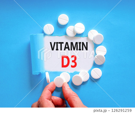 Vitamin D3 symbol. Concept words Vitamin D3 on beautiful white paper. White pills tablets. Doctor's hand. Beautiful blue background. Medical healthy lifestyle Vitamin D3 concept. 126291259
