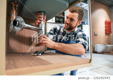 Busy worker in blue uniform is in the bathroom 126292045