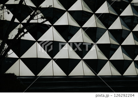 A building with a geometric design on the surface. A detailed shot of a building facade features a monochromatic pattern. Urban real estate. A building with a geometric design on the surface. A detailed shot of a building facade features a monochromatic pattern. Urban real estate. 126292204