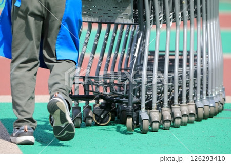 ショッピングカートの列を押すスタッフ ショッピングカートの列を押すスタッフ 126293410