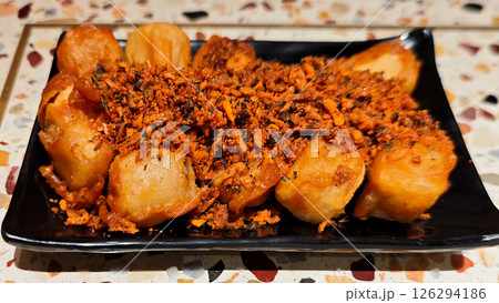 Crispy Fried Tofu Topped with Spicy Garlic Seasoning on a Black Plate Crispy Fried Tofu Topped with Spicy Garlic Seasoning on a Black Plate 126294186
