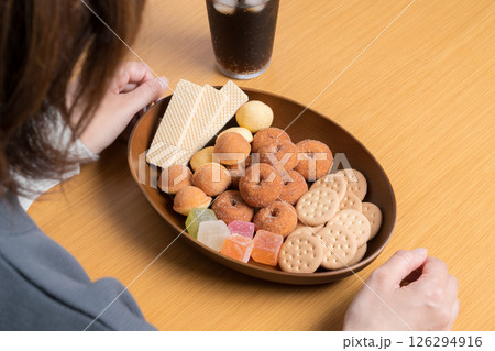 女性の前に用意された美味しそうな甘いお菓子の盛り合わせ 126294916