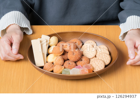 女性の前に用意された美味しそうな甘いお菓子の盛り合わせ 126294937