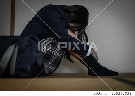 和室内で体育座りする女子高生　いじめ　不登校　ひきこもり　将来の不安　 126295032