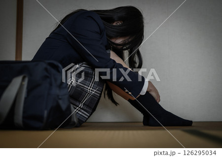 和室内で体育座りする女子高生　いじめ　不登校　ひきこもり　将来の不安　 126295034