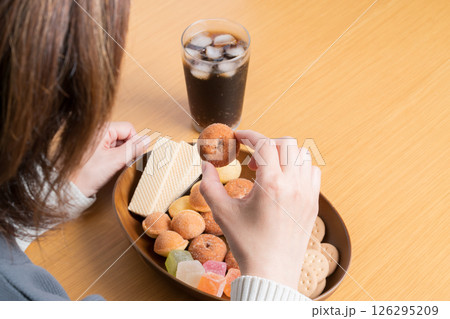 甘いお菓子の盛り合わせを食べる女性 甘いお菓子の盛り合わせを食べる女性 126295209