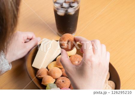 甘いお菓子の盛り合わせを食べる女性 126295210