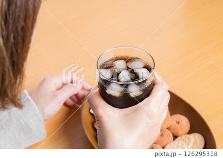 おやつにお菓子の盛り合わせを食べながらコーラを飲む女性 126295318