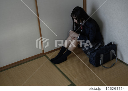 和室内の隅で体育座りする女子高生 いじめ 不登校 ひきこもり 将来の不安 和室内の隅で体育座りする女子高生 いじめ 不登校 ひきこもり 将来の不安 126295324