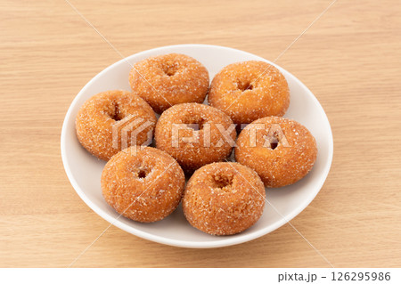 お皿に盛りつけた美味しそうなミニドーナツ 126295986