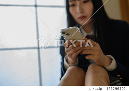 和室内でスマホを見る女子高生 いじめ 不登校 SNSトラブル ナチュラルカラー 和室内でスマホを見る女子高生 いじめ 不登校 SNSトラブル ナチュラルカラー 126296392