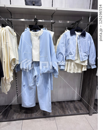 The contemporary clothing boutique features a fashionable collection of casual clothing hanging on hangers 126296554