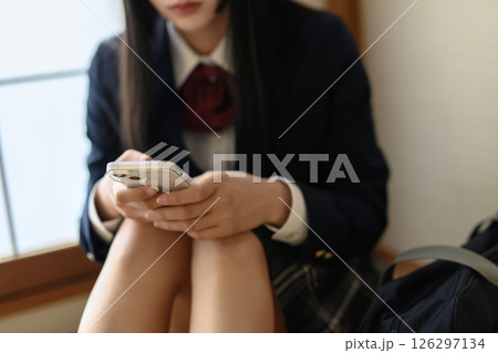 和室内でスマホを見る女子高生　連絡　進路相談　SNS　ナチュラルカラー 126297134
