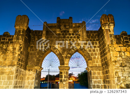 Entrance Gate of Mercado de Artesanias or craft market of Masaya in Nicaragua features Gothic-inspired pointed arches and crenellated battlements lit by soft evening lamps, framing a twilight sky over 126297343