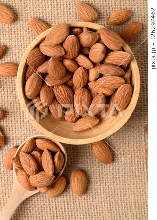 Raw almond nut seed in wooden spoon and bowl, Top view Raw almond nut seed in wooden spoon and bowl, Top view 126297462