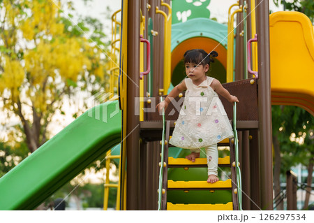 happy toddler girl playing at a outdoor playground in park happy toddler girl playing at a outdoor playground in park 126297534
