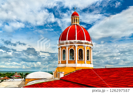 Vibrant red dome of Granada’s iconic cathedral rises against a dramatic sky, showcasing neoclassical architecture and offering sweeping views over the city and Lake Nicaragua. Vibrant red dome of Granada’s iconic cathedral rises against a dramatic sky, showcasing neoclassical architecture and offering sweeping views over the city and Lake Nicaragua. 126297587