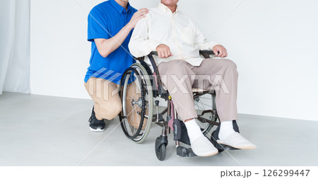 男性介護士と車椅子に乗った高齢者男性 126299447