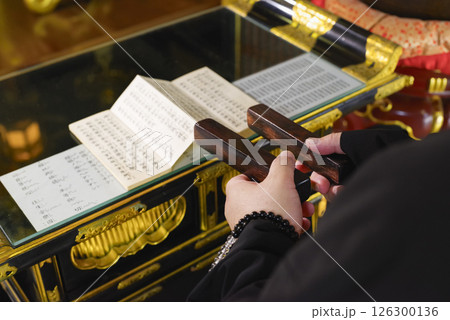 お寺の本堂で読経をするお坊さん 126300136