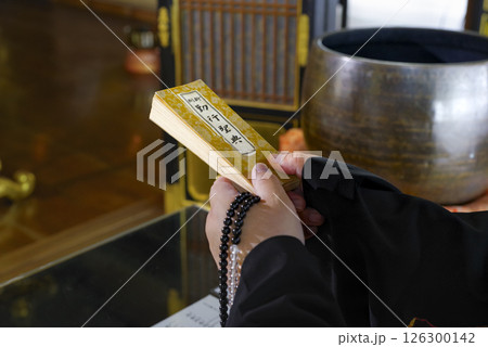 お寺の本堂で読経をするお坊さん 126300142