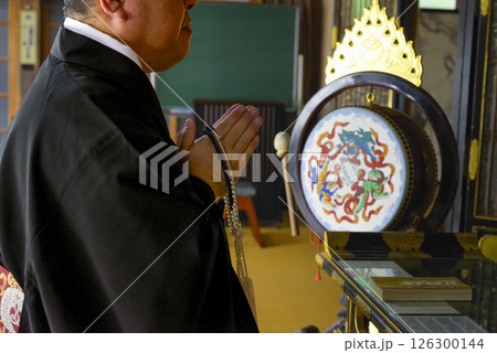 お寺の本堂で読経をするお坊さん お寺の本堂で読経をするお坊さん 126300144