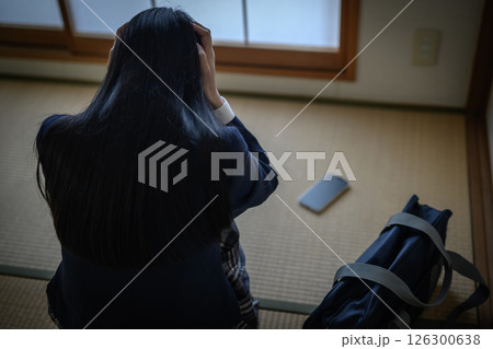 和室の畳に置かれたスマホを見る女子高生　いじめ　不登校　SNSトラブル　朝カラー　ピント人物 126300638