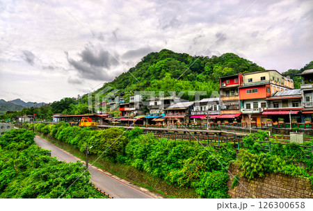 Colorful houses and shops line the tracks of the historic Pingxi railway in Shifen Village, nestled among forested hills in New Taipei, Taiwan. This popular destination is known for its lantern 126300658