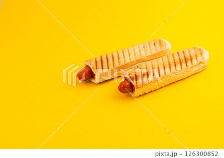 Savory snack of sausage in a crispy waffle cone on yellow Savory snack of sausage in a crispy waffle cone on yellow 126300852