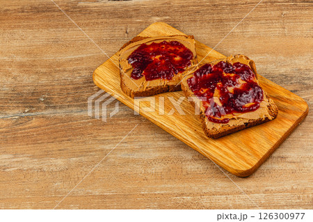 Classic peanut butter and jelly toast on a wooden serving board 126300977