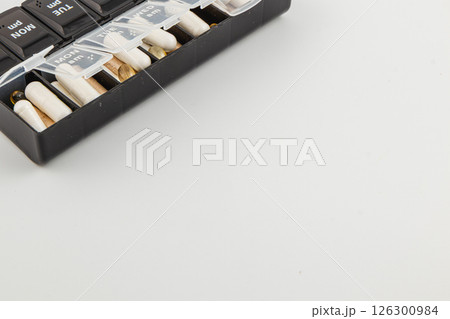 Daily medication organizer with labeled compartments for pills 126300984