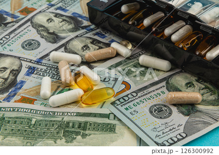 Pills and cash displayed together on a surface for analysis Pills and cash displayed together on a surface for analysis 126300992