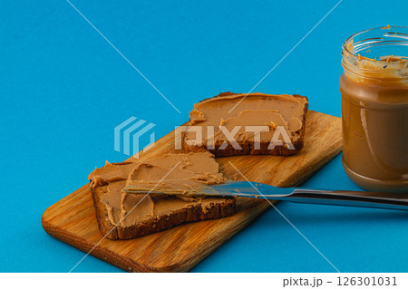 Slices of bread topped with creamy spread on a wooden board 126301031