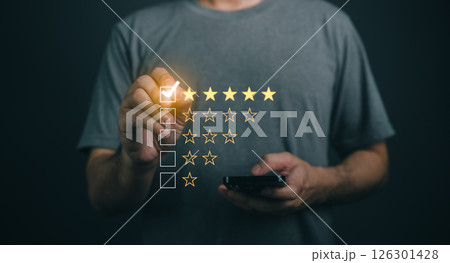 Close-up businessman hand Using Mobile Device to Rate Experience with Star Ratings on Dark Background, Customer Feedback Concept, Evaluation and Review Process Close-up businessman hand Using Mobile Device to Rate Experience with Star Ratings on Dark Background, Customer Feedback Concept, Evaluation and Review Process 126301428